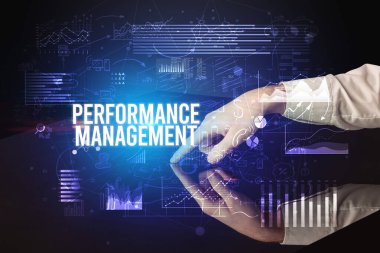 İş adamı Performans Yönetimi yazıtları ve siber iş konseptiyle büyük ekrana dokunuyor.