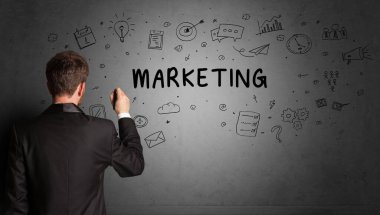İş adamı, MARKETING yazıtları ve iş stratejisi konseptiyle yaratıcı bir fikir çizimi yapıyor.