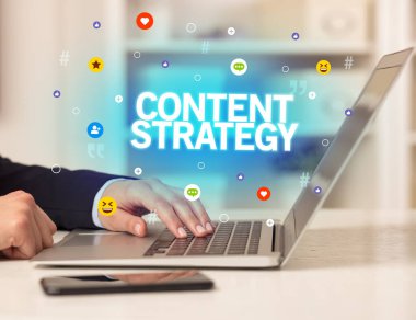 CONTENT STRATEGY yazıtlı, Sosyal medya konseptli dizüstü bilgisayar kullanan serbest çalışan kadın