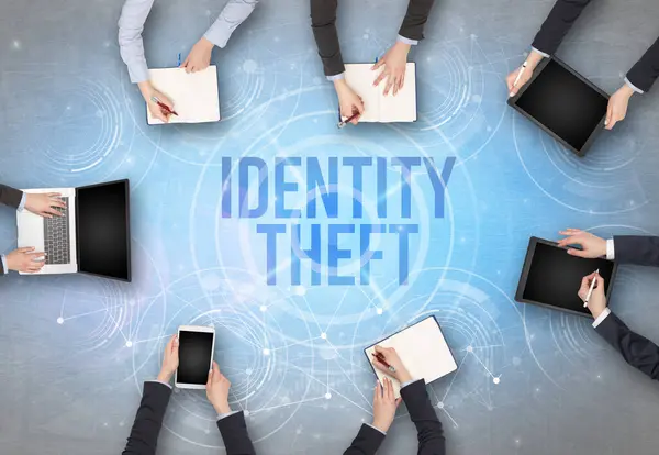 Group of people in front of a laptop with IDENTITY THEFT insciption, web security concept
