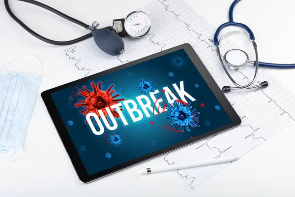 Tablet pc and doctor tools on white surface with OUTBREAK inscription, pandemic concept