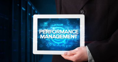 Tablet üzerinde çalışan genç iş adamı ve yazıyı gösteriyor: Performans Yönetimi, iş konsepti