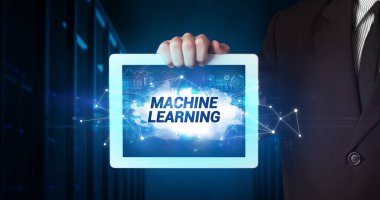 Tablet üzerinde çalışan genç iş adamı ve yazıyı gösteriyor: MACHINE EĞİTİM