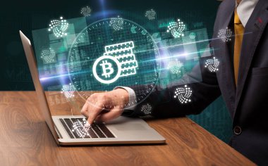İşadamı, bilgisayar ekranından çıkan bitcoin tasarruf simgeleriyle borsada çalışıyor