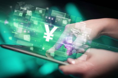 Yen simgelerinin çıktığı tablet kullanan bir elin yakın çekimi, dijital para birimi kavramı
