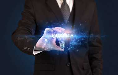 Nitelik ve yenilikçi teknoloji kavramına sahip bir iş adamı elinde ampul tutuyor.