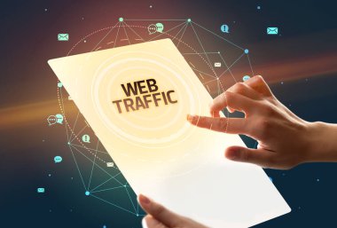 WEB TRAFFIC yazıtları ve sosyal medya kavramı içeren fütüristik tablet tutuluyor