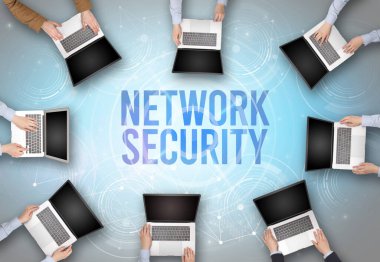 NETWORK GÜVENLİK içgüdü, web güvenliği kavramına sahip bir dizüstü bilgisayarın önünde bir grup insan