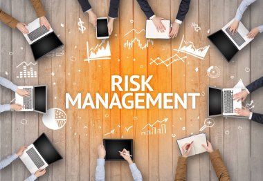 RISK MANAGEMENT yazıtları ve başarılı iş konseptiyle bir ofiste çalışan bir grup meşgul insan
