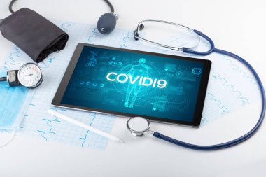 COVID19 yazıtları, koronavirüs kavramına sahip tablet bilgisayar ve doktor araçları