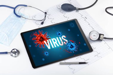 Beyaz yüzeyde VIRUS yazıtları, salgın konsepti olan tablet bilgisayar ve doktor araçları