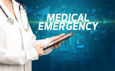 Doktor panoya MEDICAL EMERGENCY yazısını, tıbbi tanı kavramını içeren notlar yazar.