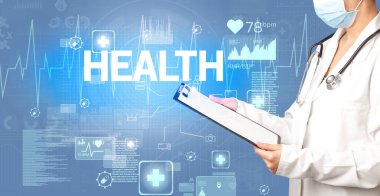 Genç doktor, sağlık sigortası kavramına ve sağlık yazısına sahip notlar yazıyor.