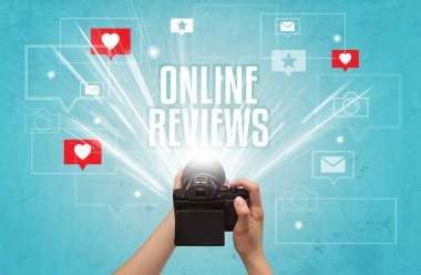 ONLINE REVIEWS yazıtları, sosyal medya kavramı ile fotoğraf çeken bir elin yakın çekimi