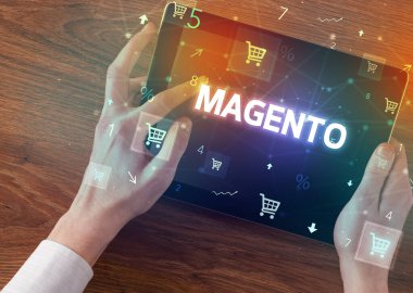 MAGENTO yazıtlı el ele tutuşma tabletinin yakın çekimi, çevrimiçi alışveriş kavramı