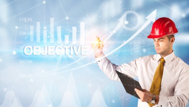 Miğferli genç işadamı OBJECTIVE yazıtları çiziyor, modern iş teknolojisi kavramı