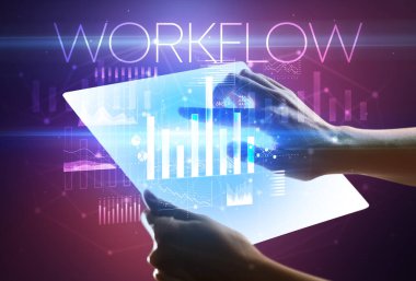 Üzerinde WorKFLOW yazıtı olan fütüristik tablet, modern iş kavramı.