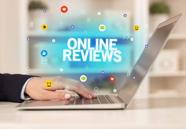 ONLINE REVIEWS yazıtlı, Sosyal medya konseptli dizüstü bilgisayar kullanan serbest çalışan kadın