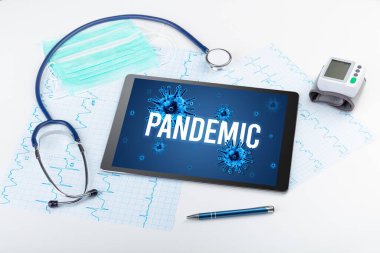 Beyaz yüzeyde PANDEMIC yazıtları, salgın konsepti olan tablet pc ve doktor araçları