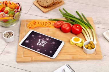 X-RAY DATA concept in tablet pc with healthy food around, top view