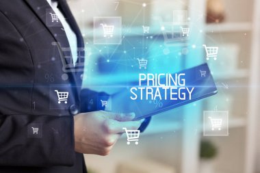 Genç kişi online alışveriş uygulaması üzerinden PRICING STRATEGY yazıtları ile alışveriş yapıyor
