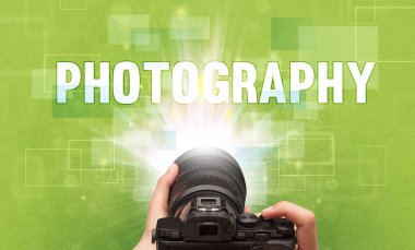 Fotografik yazı ve seyahat konseptiyle el ele tutuşan dijital kameranın yakın çekimi