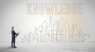 Üzerinde KNOWLEDGE yazıtları, mühendisliği ve mimari konsepti olan sağlam şapkalı bir işadamı.