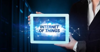 Tablet üzerinde çalışan genç iş adamı ve yazıtı gösteriyor: Nesnelerin İnterneti