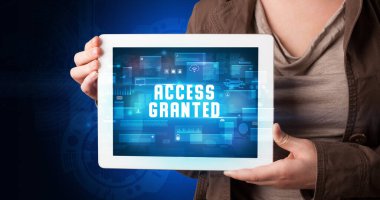 Tablet üzerinde çalışan genç iş adamı dijital işareti gösteriyor: ACCESS GRANED