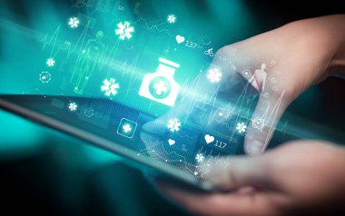 İlaç ikonlarıyla, modern sağlık hizmetleri konseptiyle dokunmatik ekrana yakın çekim