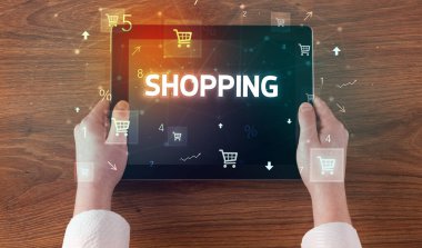 Alışveriş yazıtları ve online alışveriş konseptiyle el ele tutuşma tabletinin yakın çekimi