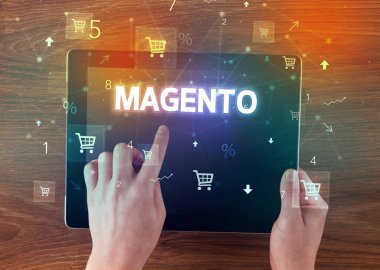 MAGENTO yazıtlı el ele tutuşma tabletinin yakın çekimi, çevrimiçi alışveriş kavramı