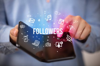 İş adamı elinde katlanabilir bir akıllı telefon tutuyor. Yazı, sosyal medya kavramı...