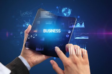 İş adamı elinde katlanabilir bir akıllı telefon tutuyor. İş dünyası yazıtları, başarılı bir iş konsepti.