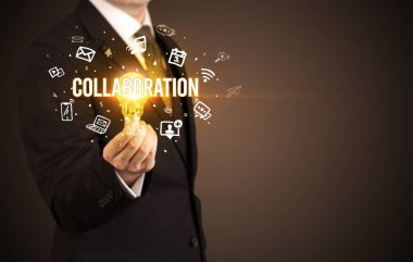 İşadamı elinde İşbirliği yazısıyla ampul tutuyor, sosyal medya kavramı