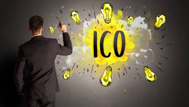 businessman drawing colorful light bulb with ICO abbreviation, new technology idea concept