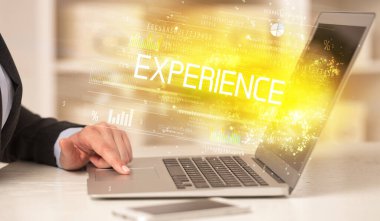 ExperIENCE yazıtları ve başarılı iş konsepti ile birlikte dizüstü bilgisayarda çalışan iş adamlarının yakınlaşması