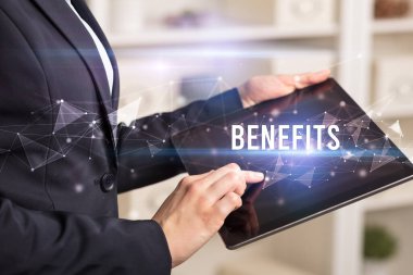 BENEFITS yazıtları ve modern iş teknolojisi kavramı olan tablet kullanarak elleri kapat