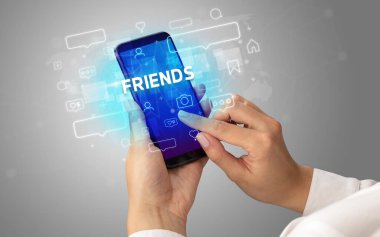 Arkadaş yazısıyla, sosyal medya konseptiyle akıllı telefondan yazı yazan bir kadın.