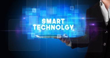 Tablet üzerinde çalışan genç iş adamı ve yazıyı gösteriyor: Akıllı TEKNOLJİ