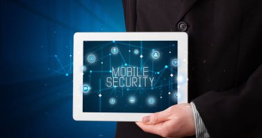 Tablet üzerinde çalışan genç iş adamı dijital işareti gösteriyor: MOBILE GÜVENLİK