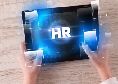 İnsan Kaynakları kısaltmalı el ele tutuşma tableti, modern teknoloji kavramı.