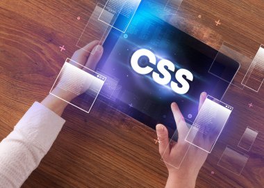 CSS kısaltmalı, modern teknoloji kavramlı el ele tutuşma tabletinin yakın çekimi