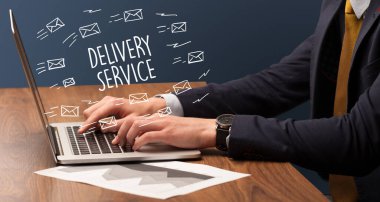 Diz üstü bilgisayarda Teslimat Servisi yazısıyla çalışan iş adamı, online alışveriş konsepti