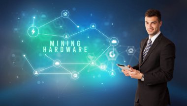Businessman in front of cloud service icons with MINING HARDWARE inscription, modern technology concept