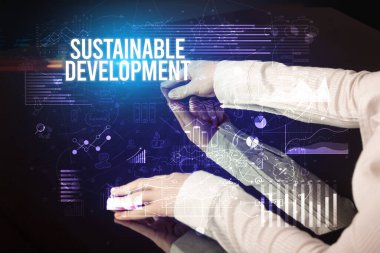 İş adamı büyük ekrana SUSTAINable DEVELOPMENT yazıtları, siber iş konsepti ile dokunuyor