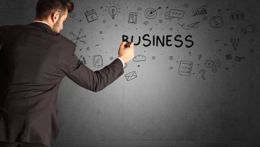 İş adamı, BUSINESS yazıtları ve iş stratejisi konseptiyle yaratıcı bir fikir çizimi yapıyor.