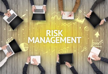 RISK MANAGEMENT yazıtları ve başarılı iş konseptiyle bir ofiste çalışan bir grup meşgul insan