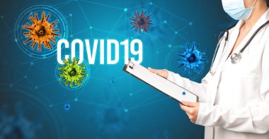 Doktor COVID19 yazıtlı reçete yazıyor, salgın konsepti.