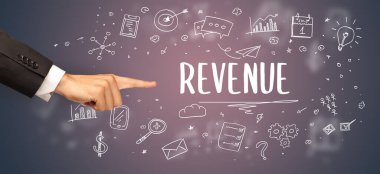 Kırpılmış ellerin yakın çekimi REVENUE yazıtına işaret ediyor, modern iş çözümleri kavramı